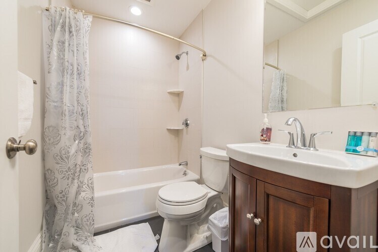 A bathroom with a toilet, sink, and shower.