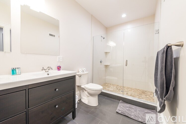 A bathroom with a toilet, sink, and shower.