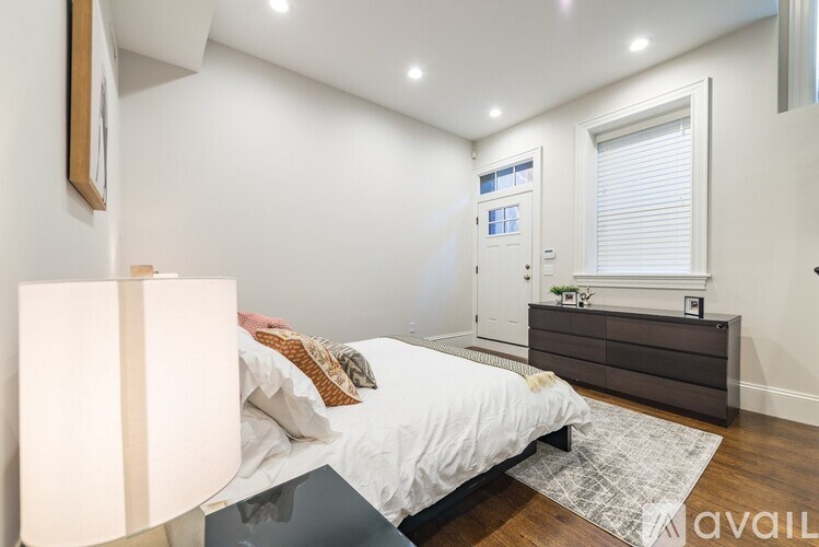 A bedroom with a bed, nightstand, and lamp.