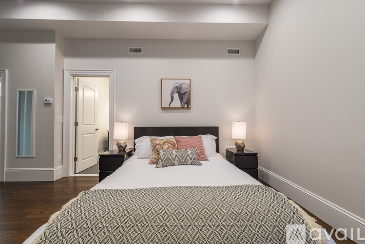 A bedroom with a large bed and a painting above it.