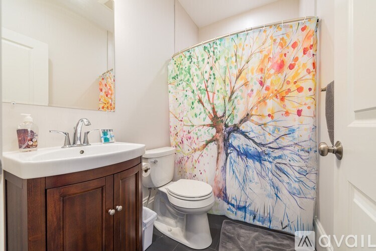A bathroom with a tree painted on the shower curtain.