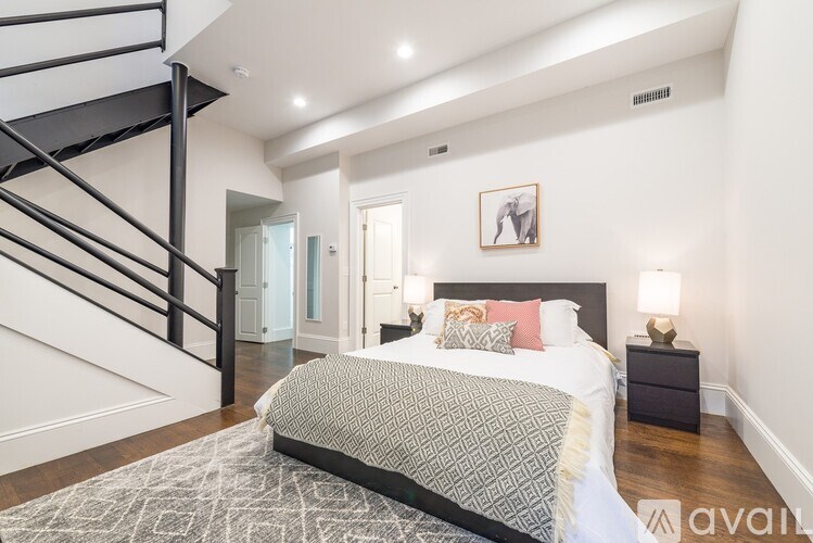 A bedroom with a large bed and a staircase.