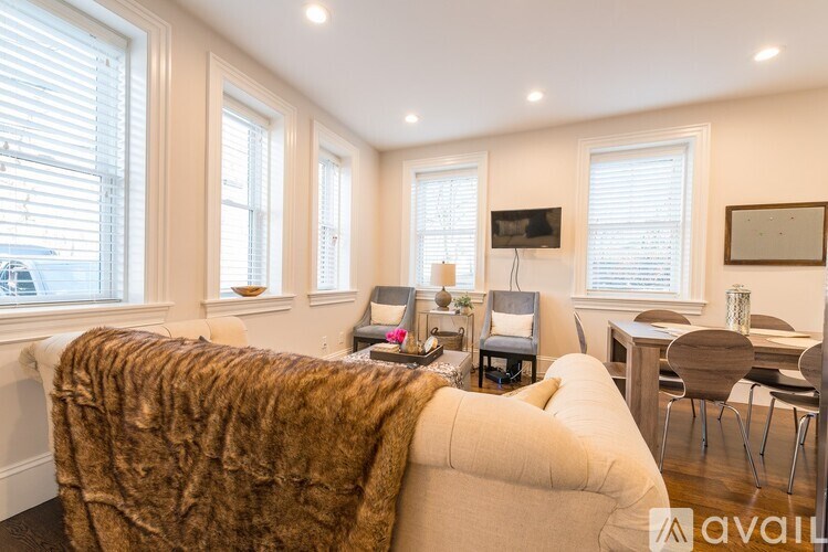 A living room with a couch, a chair, a coffee table, and a television.