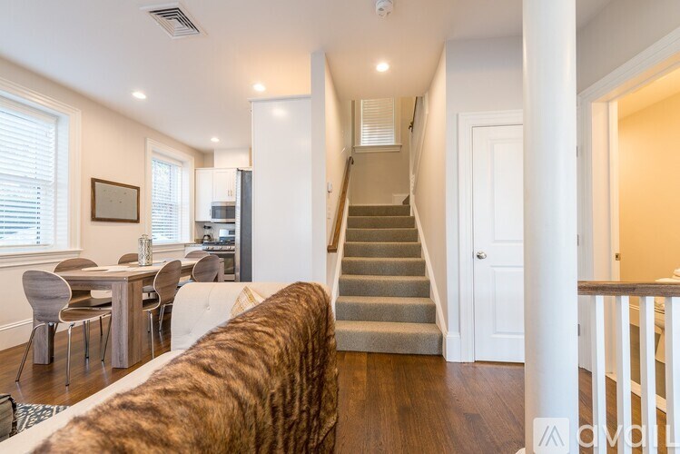 A living room with a couch, chairs, and a dining table.