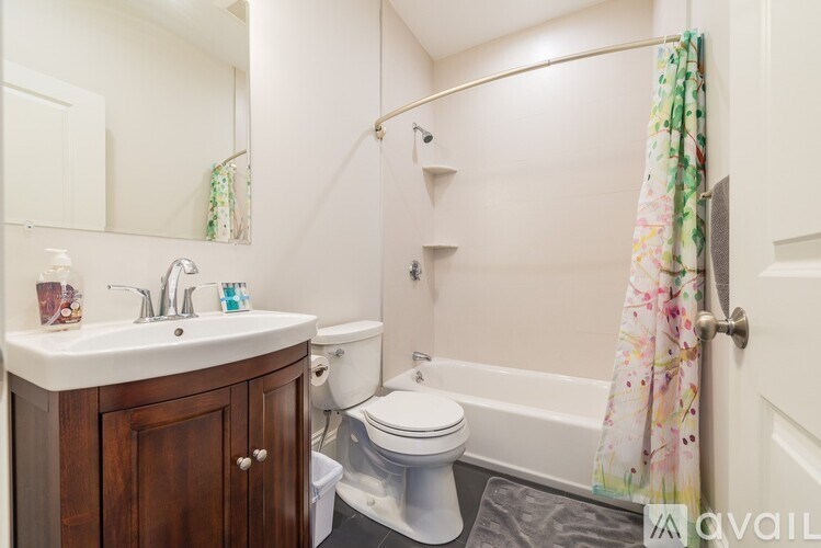 A small bathroom with a toilet, sink, and shower.