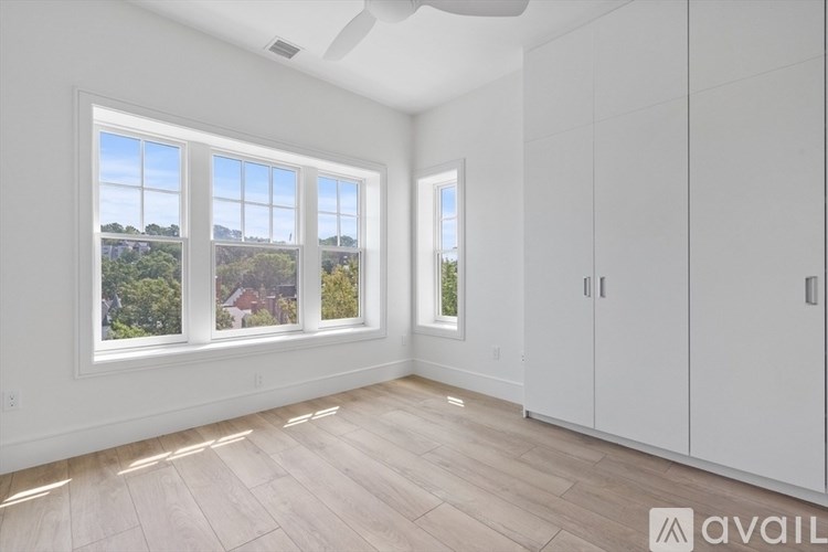 A room with a large window and a wooden floor.