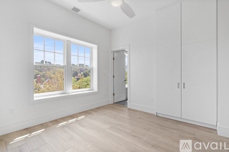 A room with a large window and a wooden floor.