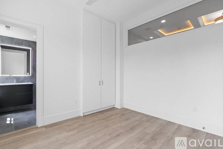 A spacious room with a built-in entertainment center and wooden flooring.