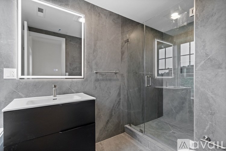 A bathroom with a sink, mirror, and walk-in shower.