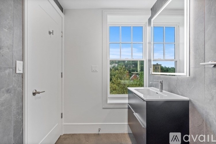 A bathroom with a large window and a sink.