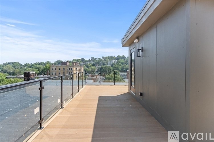 A balcony with a railing overlooking a body of water and a building in the distance.