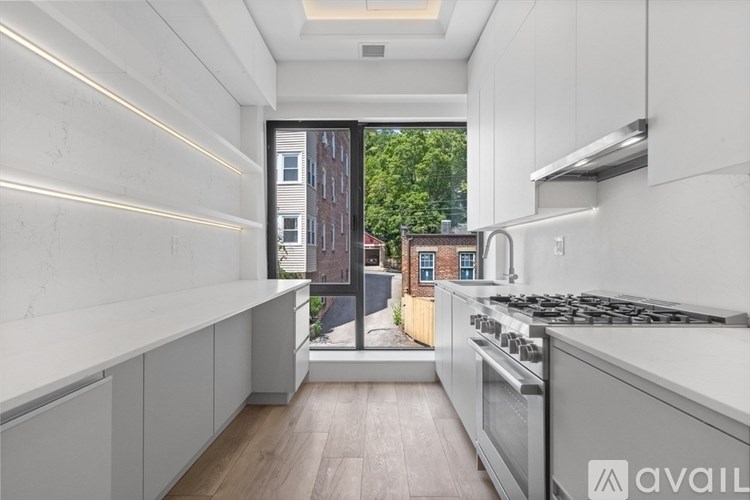 A modern kitchen with a stainless steel stove and white cabinets.