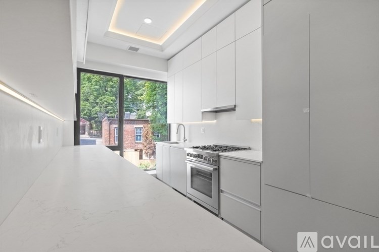 A modern kitchen with white cabinets and appliances.