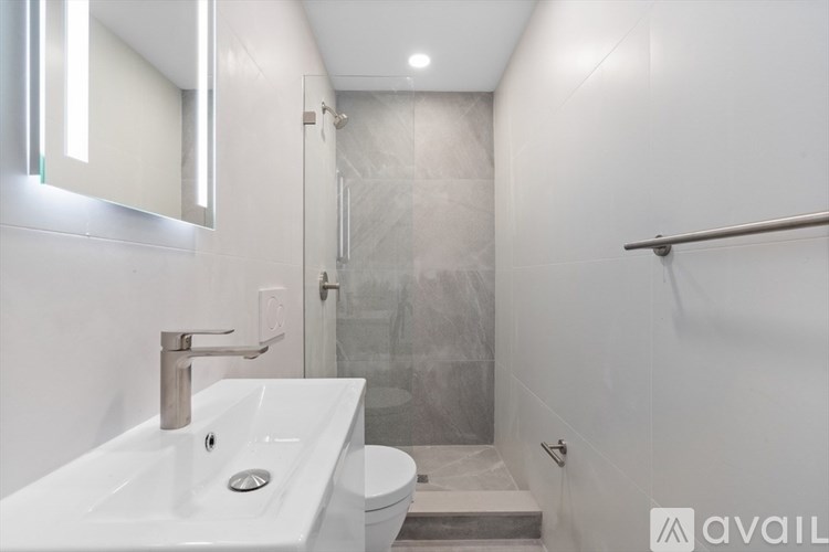 A bathroom with a sink, toilet, and shower.