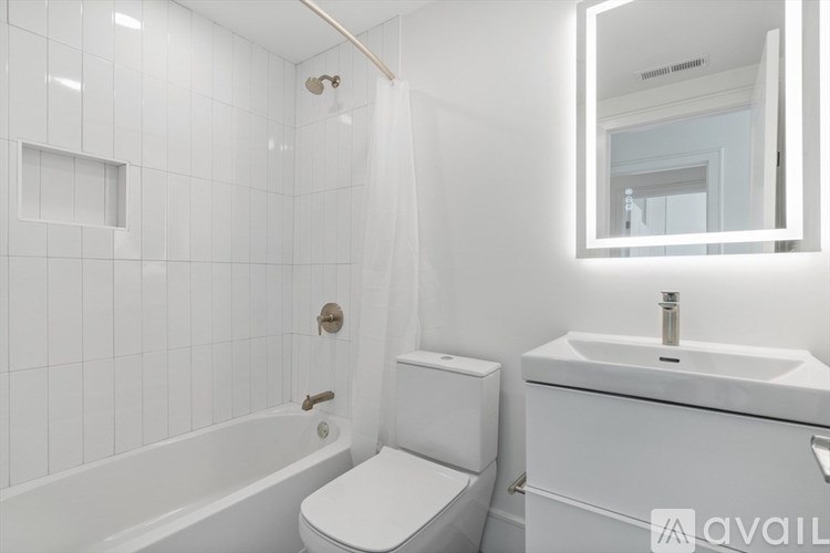 A white bathroom with a toilet, sink, and bathtub.