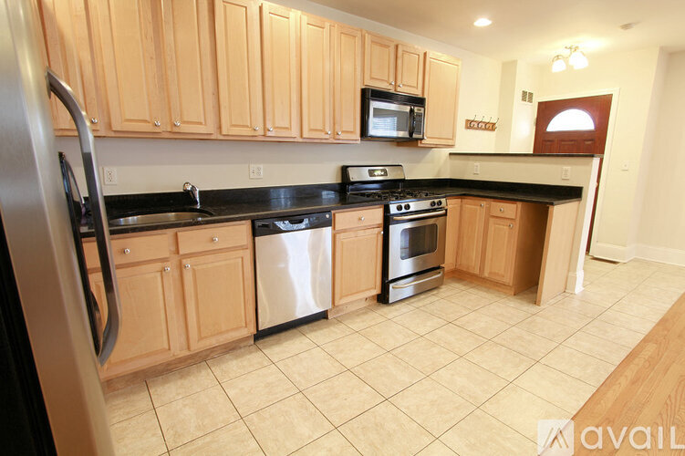 A kitchen with wooden cabinets and black appliances.