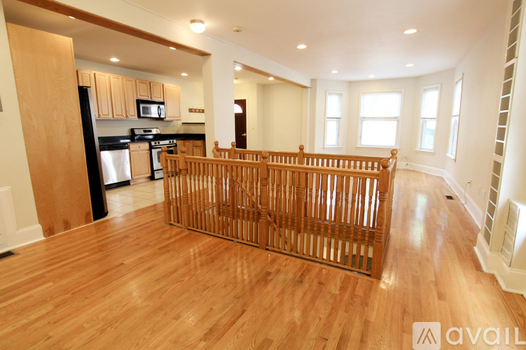 A kitchen with wooden floors and a wooden railing.