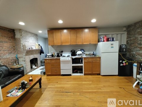 A kitchen with wooden floors and a brick wall.