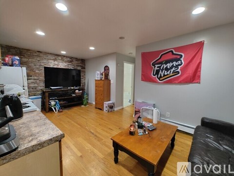 A living room with a flat screen TV and a red banner on the wall.