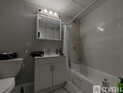 A bathroom with a white tub, sink, and mirror.