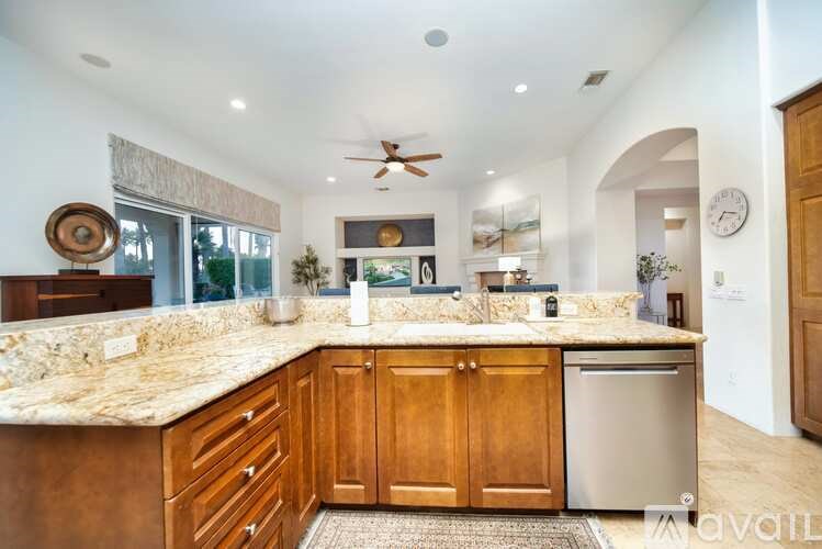 A kitchen with a marble countertop and wooden cabinets.