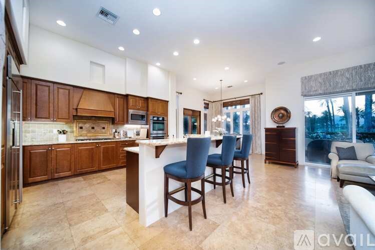 A kitchen with a bar and chairs in front of a window.