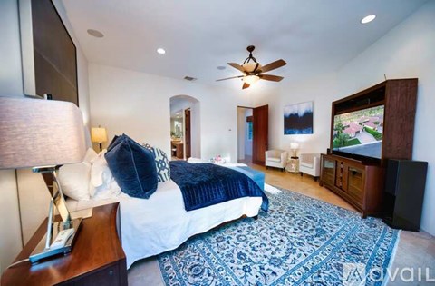 A bedroom with a large bed and a flat screen TV.