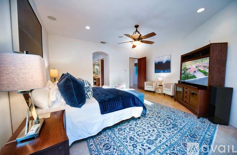 A bedroom with a large bed and a flat screen TV.