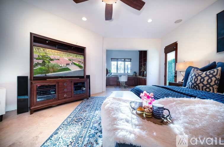 A living room with a large flat screen TV and a blue sofa.