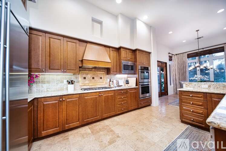 A kitchen with wooden cabinets and a marble countertop.