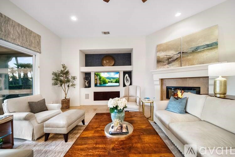A living room with a white couch, a coffee table, and a fireplace.