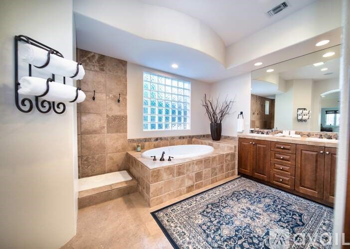 A bathroom with a tub, sink, and mirror.