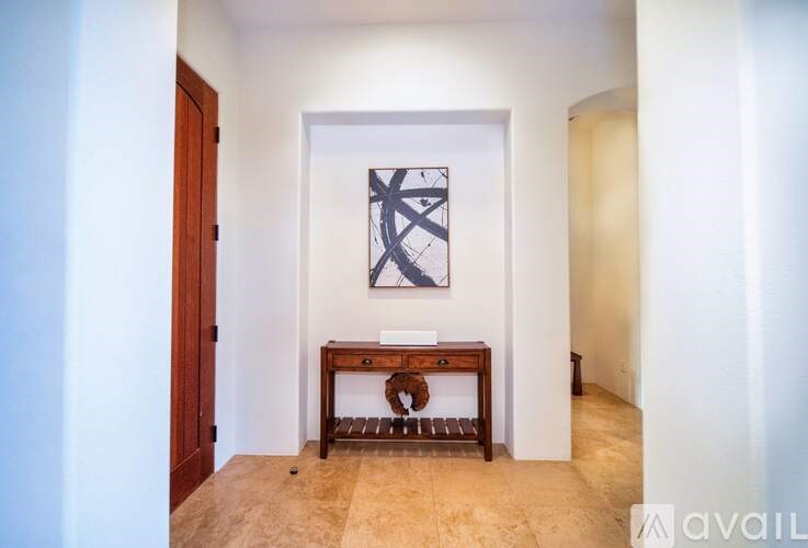 A room with a wooden table and a framed picture on the wall.