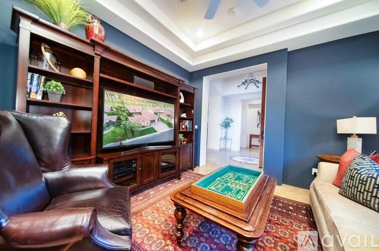 A living room with a brown leather chair and a wooden coffee table.