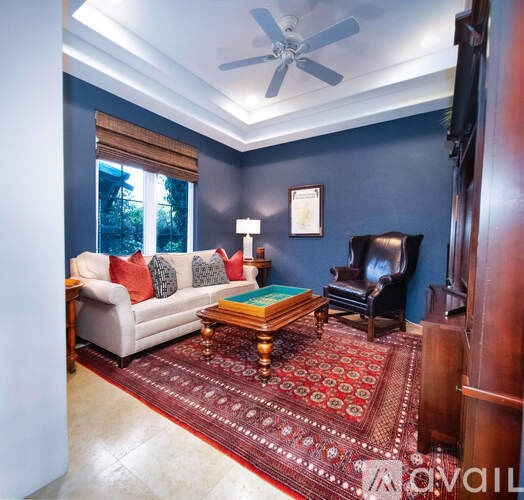 A living room with a couch, chair, and rug.