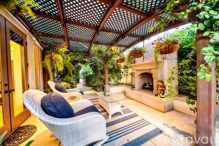 A patio with a white chair and a fireplace.