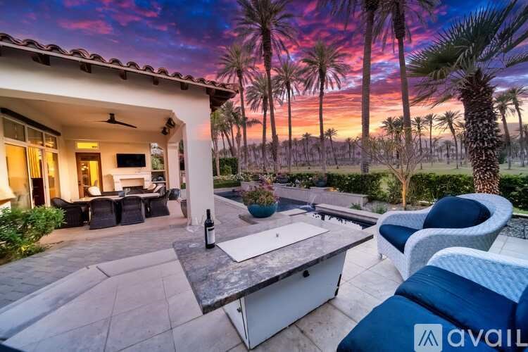 A house with a patio and a table with chairs is available for rent.