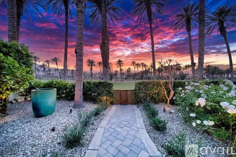 A garden with a gravel path leading to a green container.