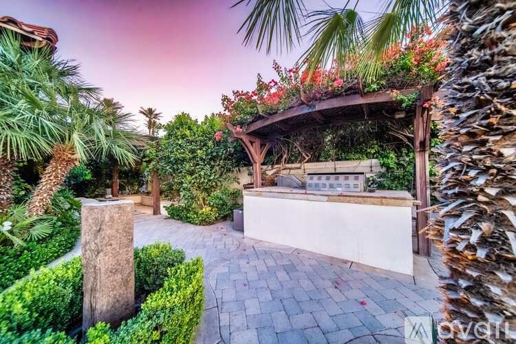 A garden with a wooden pergola and a stone pathway.