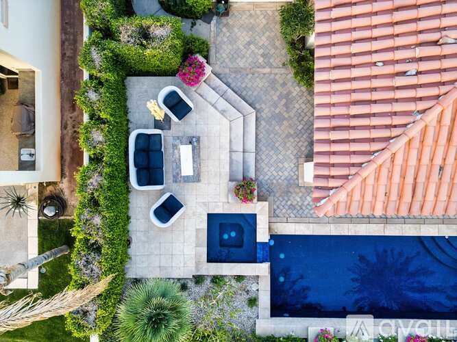 A modern outdoor patio area with a table and chairs.