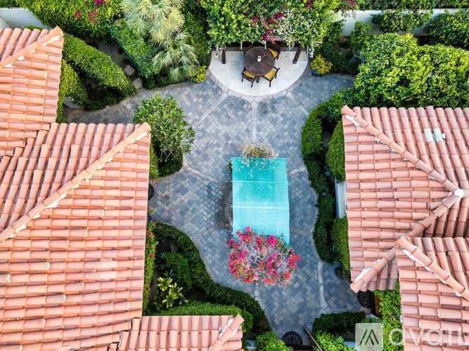 A bird's eye view of a courtyard surrounded by red tiled roofs.