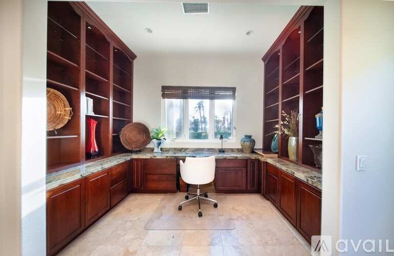 A kitchen with dark wood cabinets and a white chair.
