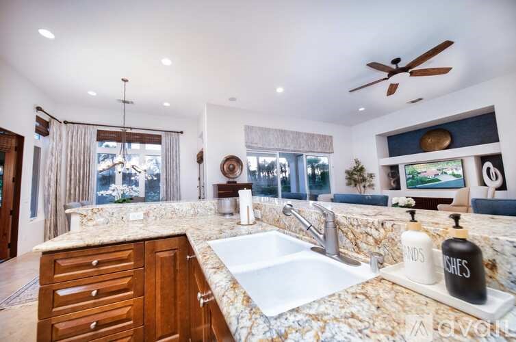 A bathroom with a marble countertop and a large window.