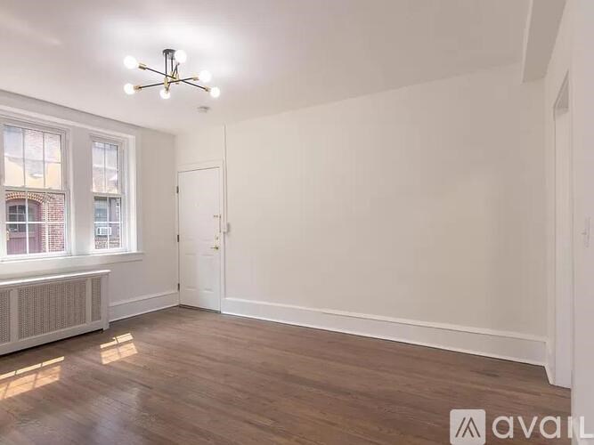 A room with wooden floors and a window with a view of a building outside.