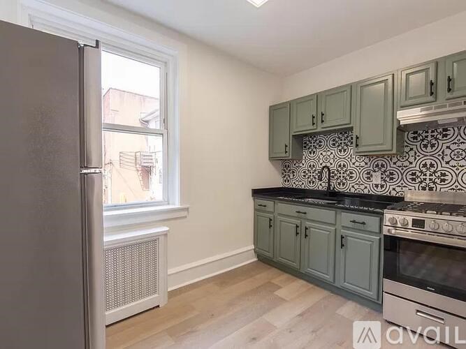 A kitchen with a refrigerator, oven, and cabinets.
