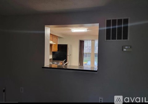 A mirror on a wall reflects a living room with a couch and a television.
