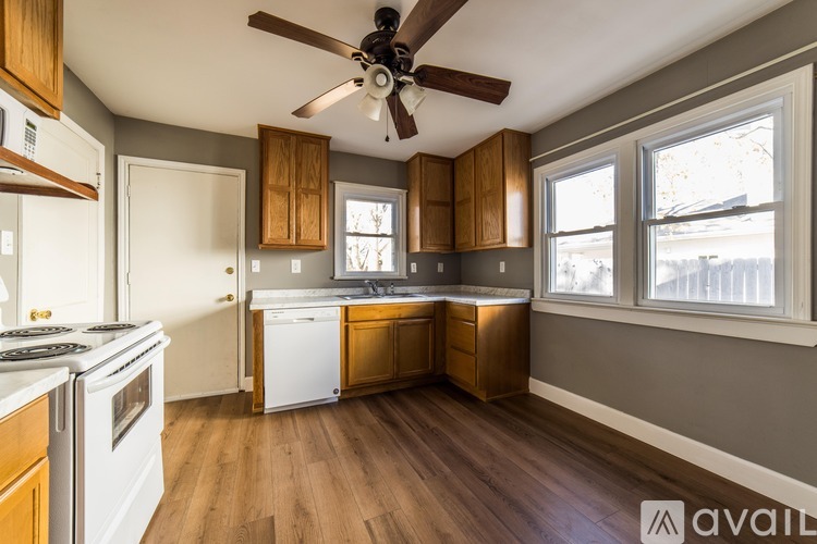 A kitchen with wooden cabinets and a white stove top oven.