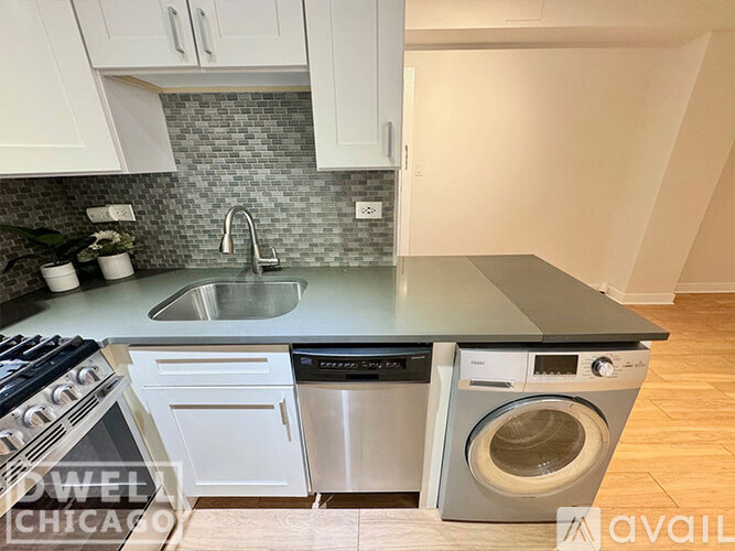 A modern kitchen with a stove top oven, dishwasher, and a washing machine.