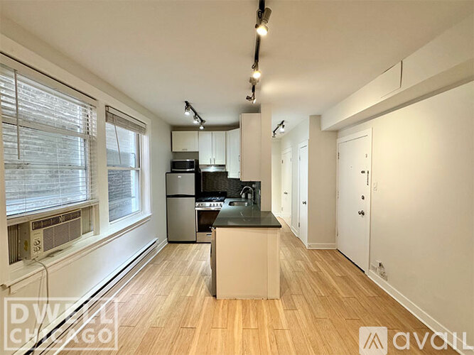A kitchen with a black countertop and white cabinets.