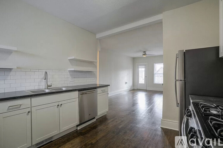 A kitchen with white cabinets and a black countertop.